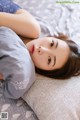 A woman laying on a bed with a pillow.