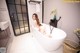 A woman sitting in a bathtub in a bathroom.