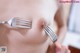 A woman holding a fork over her breast.