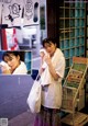 A woman standing in front of a store holding a towel.