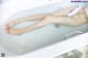 A woman laying in a bathtub with her feet in the water.