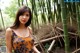 A woman standing in front of a bamboo forest.