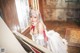 A woman in a white dress sitting at a piano.